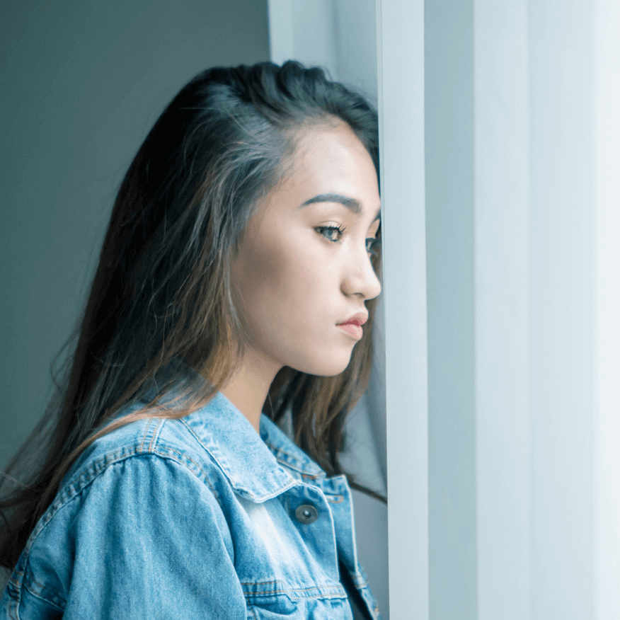 young teen looking out the window struggling with addiction
