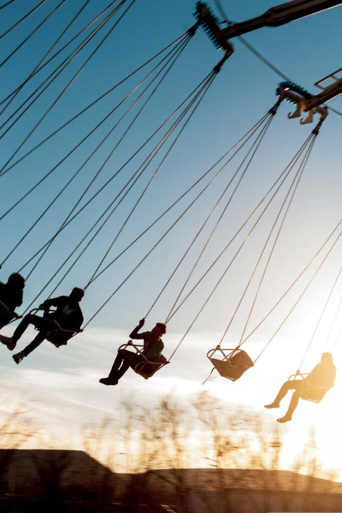 teens riding a swing ride at a fair as dusk