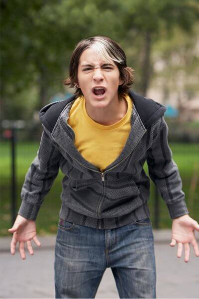 Dramatic, upset teen boy outdoors