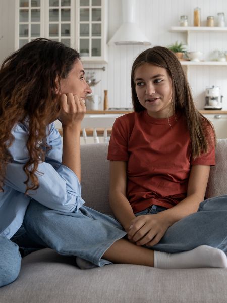 A mom listens as her adolescent daughter talks about a problem