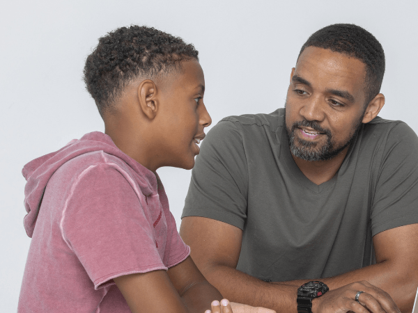 A father listens to his teen son in support of his mental health