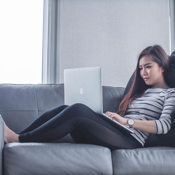 Young girl laying on couch with laptop