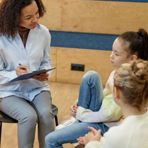 A therapist listens and takes notes during adolescent mental health therapy and counseling