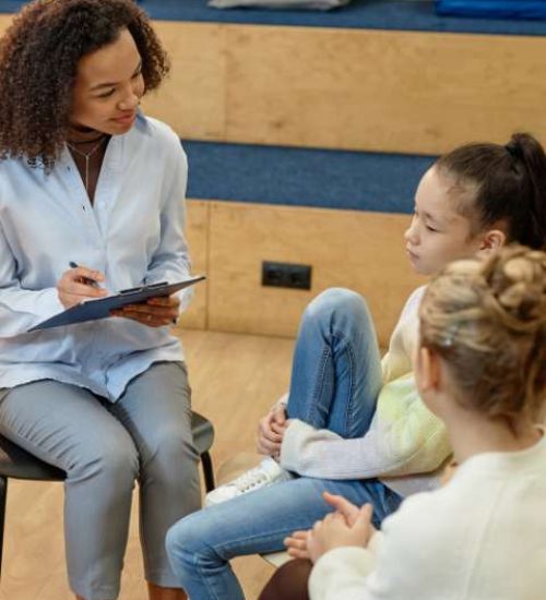 A therapist listens and takes notes during adolescent mental health therapy and counseling