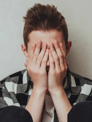 Young boy with his hands to his face as he struggles with mental health issues in Dallas, TX