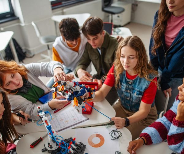 Teens working together on a school project, showing benefits of attending school during mental health treatment