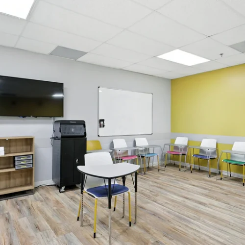 basepoint-academy-forney-teen-mental-health-facility-community-room-yellow-with-tv-and-whiteboard