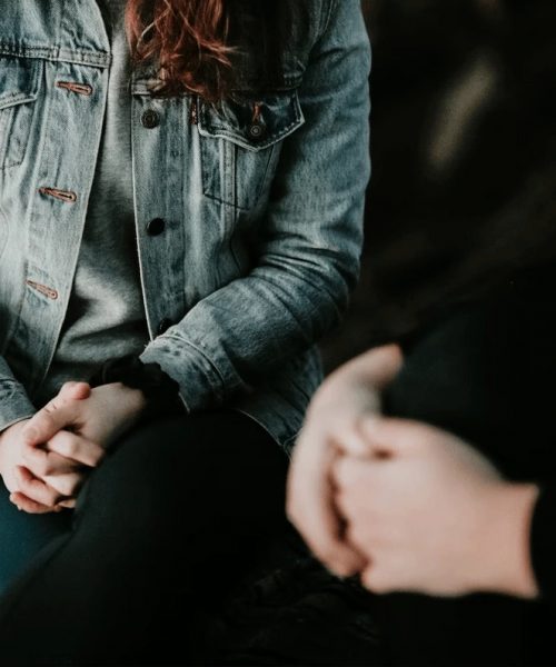 Two people shown in a group therapy session