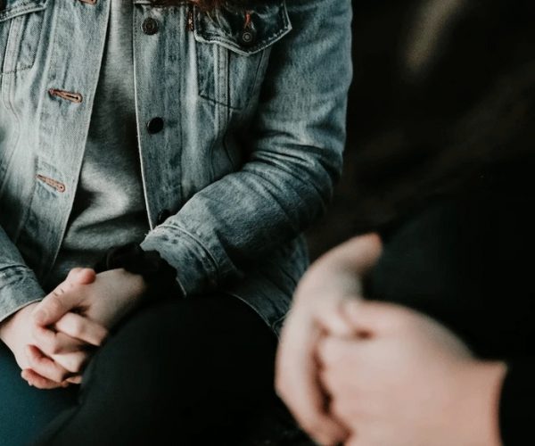 Two people shown in a group therapy session
