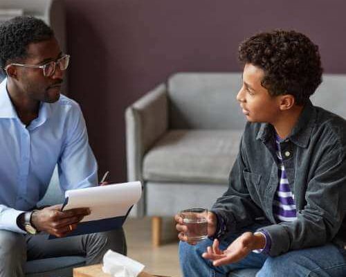 An adolescent boy talks to his therapist