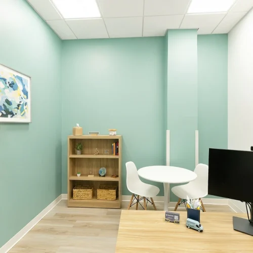 Therapist's office with mint green walls, abstract art, and a small table for two at BasePoint Academy North Richland Hills
