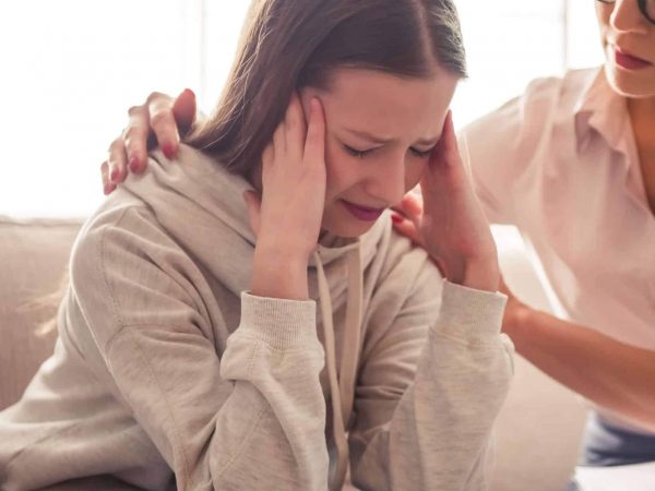 young girl and her mother hug as the young girl struggles with mental health issues