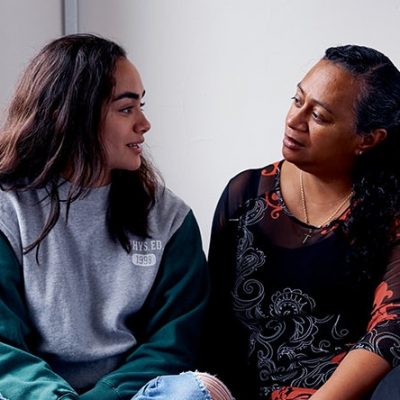 Mother and daughter sit next to each other as they discuss the costs of mental health treatment