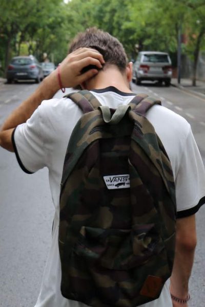 Young boy wearing a backpack with back turned dealing with mental health issues as a teen