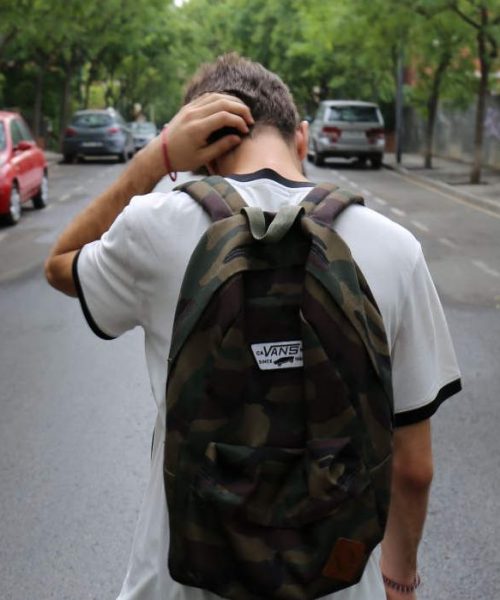 Young boy wearing a backpack with back turned dealing with mental health issues as a teen