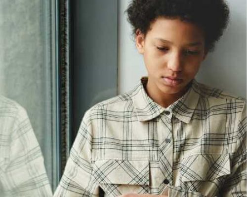 A teen look at a laptop during online therapy