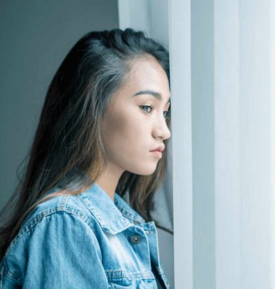 young teen looking out the window struggling with addiction