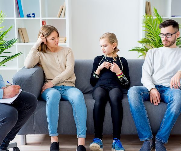 A teen girl and her parents attend a therapy session